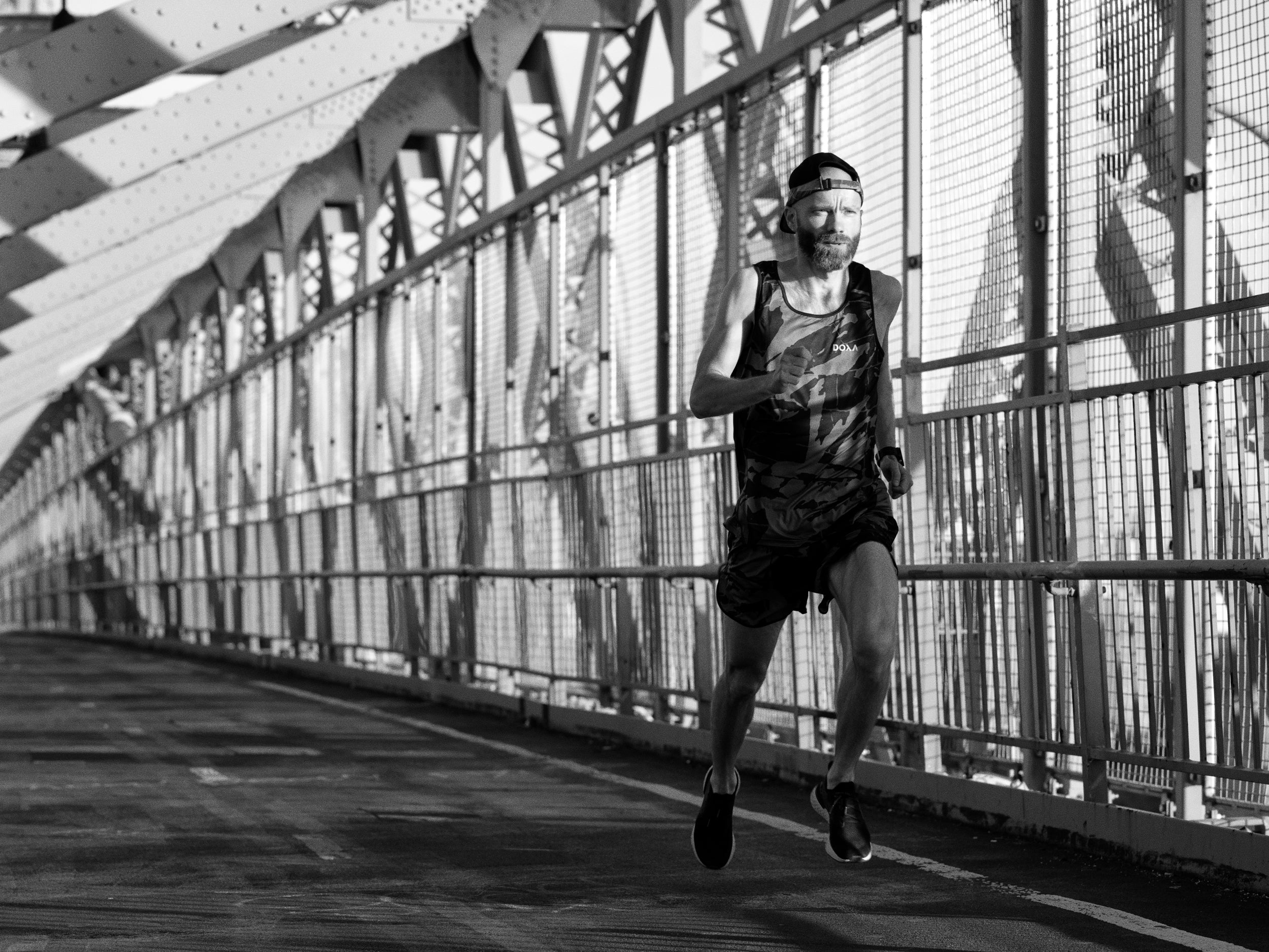 Person running on a bridge. The person is John Hansen founder of DOXA RUN.